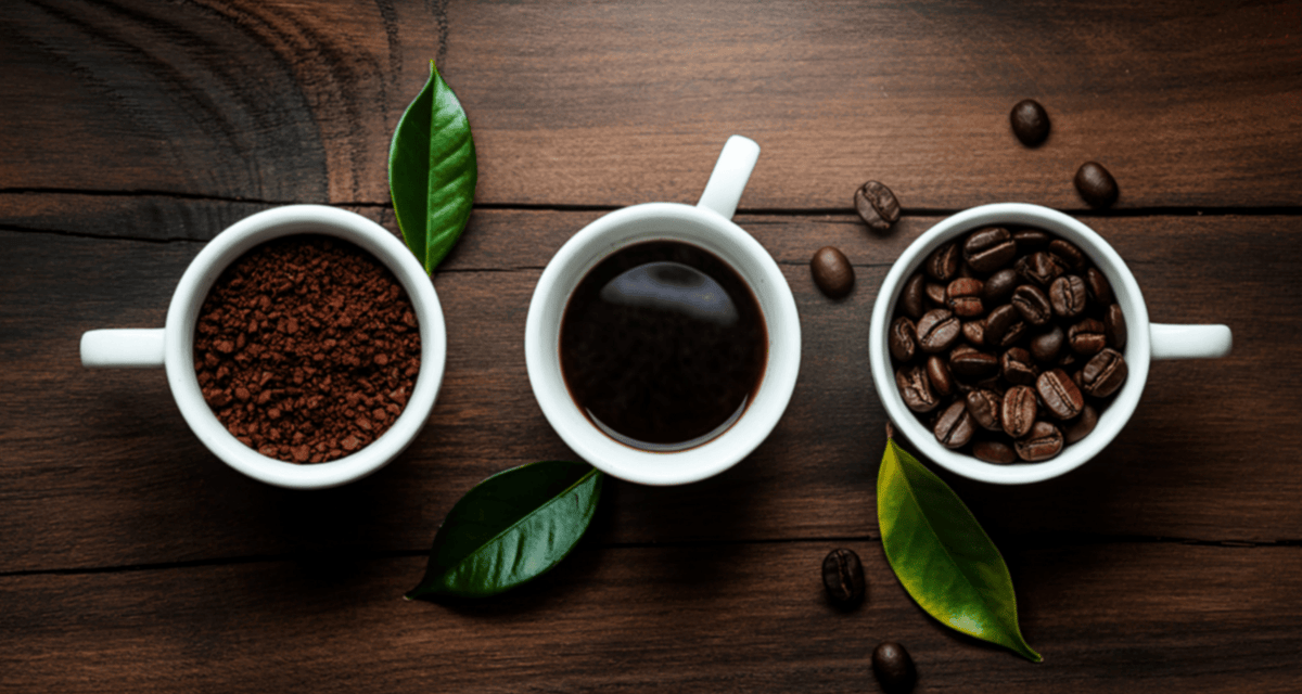 three cups of ground coffee, brewed coffee, and coffee beans surrounded by leaves and beans on a dark wood backdrop